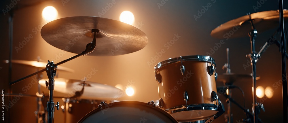 Obraz premium A dynamic view of a modern drum set illuminated by soft spotlights, evoking the energy and rhythm of live music performances in a creative studio environment.