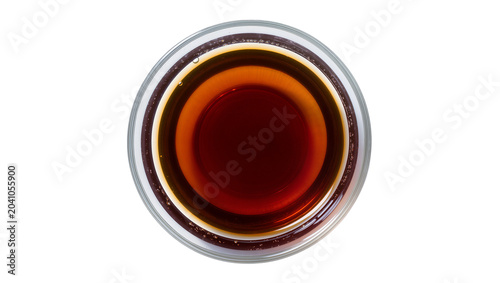 Tableau sur toile Dark amber liquid in clear glass bowl top view