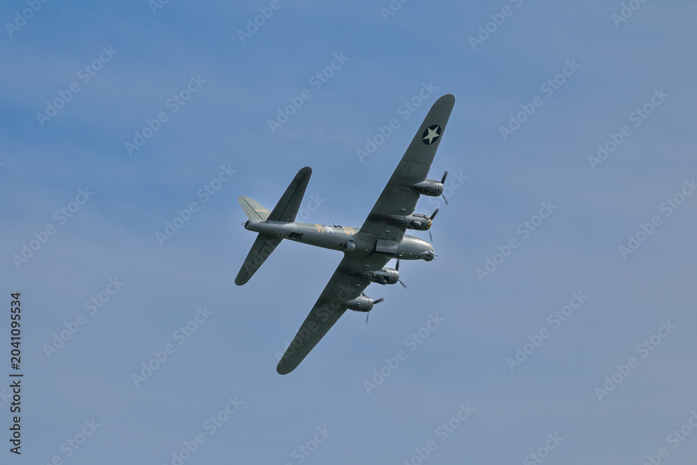 Fototapeta premium B‑17 Flying Fortress bomber in flight, showcasing its iconic World War II design, four‑engine layout, and historic military aviation heritage.