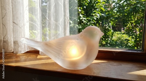 Elegant Glass Bird Lamp Decorates Windowsill with Natural Sunlight and Garden View