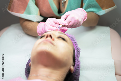 Cuadro en lienzo Woman receiving cosmetic botox injection treatment on forehead