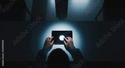 Hands Interacting With The Glowing Tablet Screen In Dark Environment