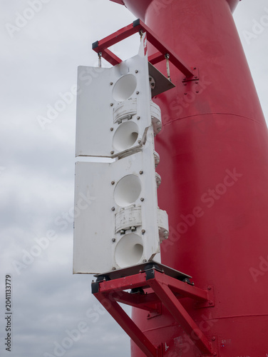 фотографія Maritime fog horn nautofon mounted on a red navigation beacon structure