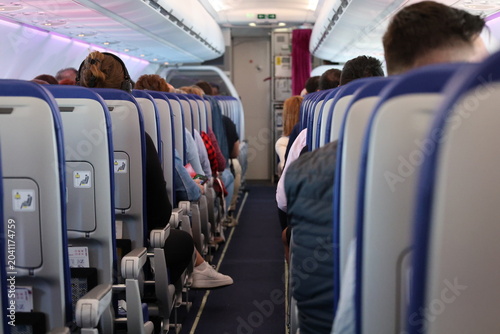 Schilderij op canvas Passengers seated inside commercial airplane cabin during flight