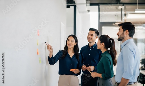 Business team discussing strategy on whiteboard.
