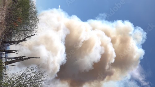 Prairie fire. Grassy-shrubby spaces are engulfed by fire during dry season. Climate change leads to increased droughts and disasters. Colored fumes and steam rises from burnt grass, plume of pollution