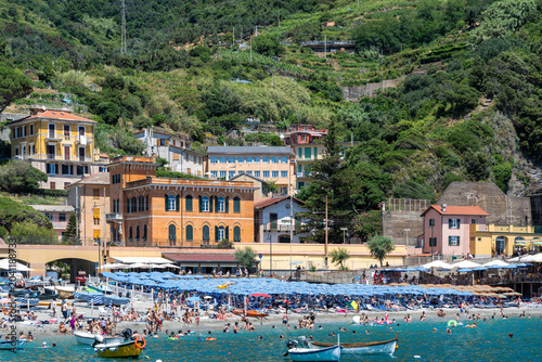 Billede på lærred Sunlit beach throngs with joyful swimmers and sunbathers in Monterosso al Mare