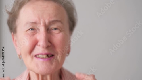 A close-up of the face of a contented, smiling, dancing old woman