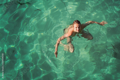 Young teenaged girl swimming in turquoise blue sea