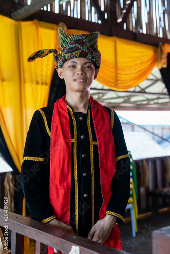 Portrait of young man smiling in traditional Kadazan Dusun attire during Kaamatan Harvest Festival in Sabah