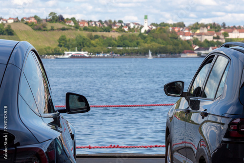 A perspective shot from the car deck of a ferry crossing Lake Constance (Bodensee). The camera is positioned between two parked cars