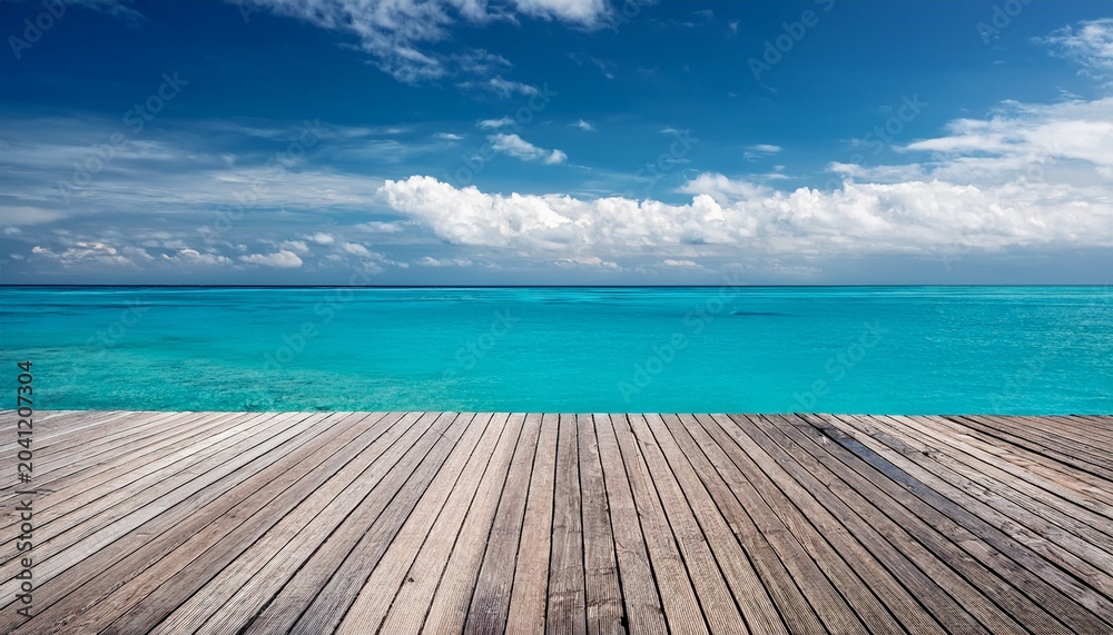 Fototapeta premium Wooden Deck Overlooks A Bright Turquoise Ocean Under A Blue Sky With Fluffy Clouds