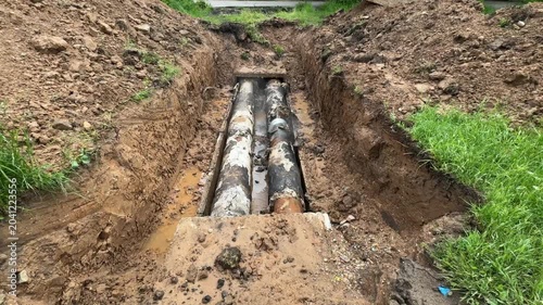 Aging heating infrastructure with worn pipeline, corrosion and damaged insulation in excavation trench