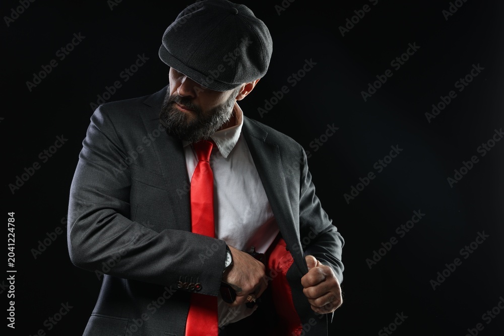 Naklejka premium Mafia. Man pulling gun out of jacket on dark background. Space for text