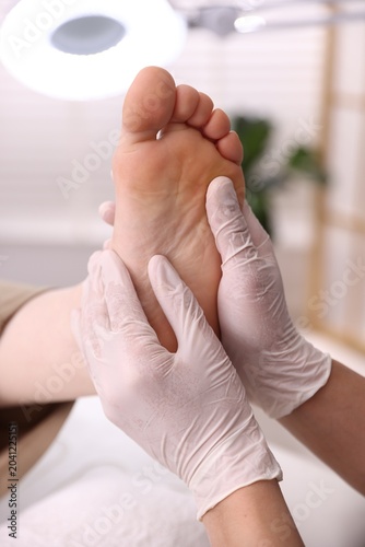Foto Professional podiatrist examining client's foot indoors, closeup