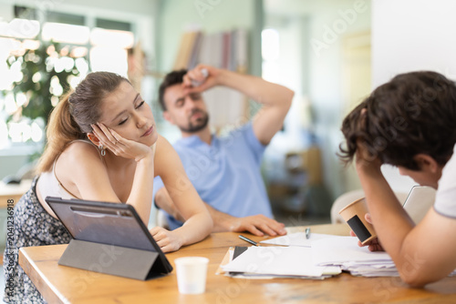 Foto Exhausted young men and woman sleeping at workplace after long stressful workday
