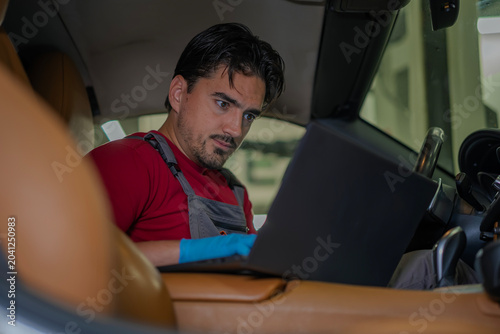 Tableau sur toile Mechanic performing car diagnostics using laptop inside car
