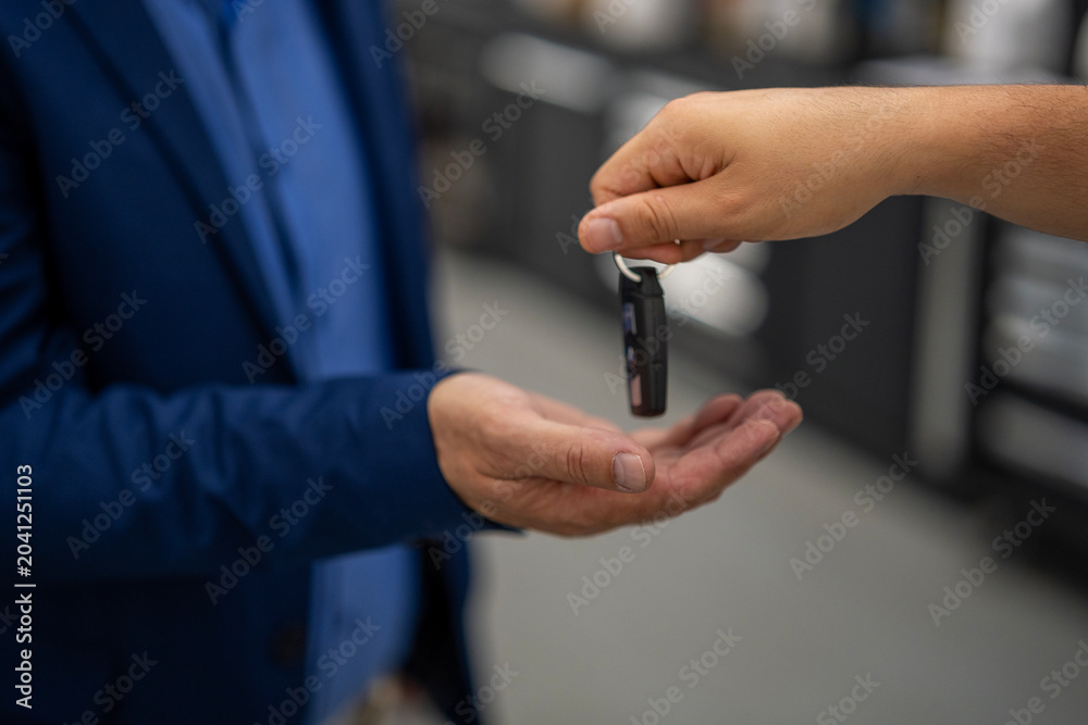 Obraz premium Hand passing car key to client closing deal