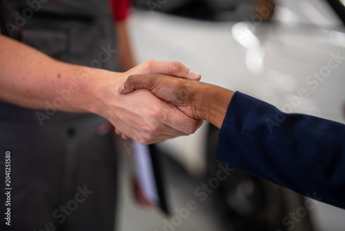 Mechanic and customer shaking hands on agreement