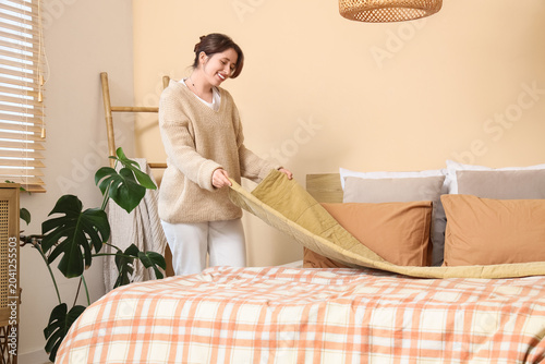 Young woman putting blanket...