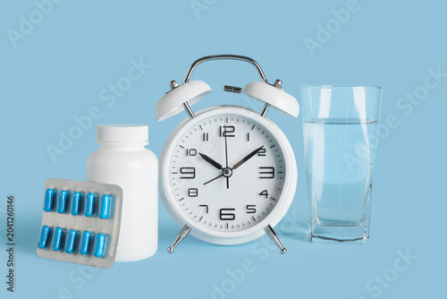 Pills, glass of water and a...