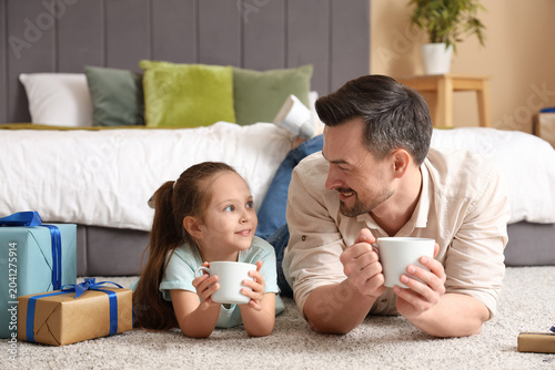 Cuadro en lienzo Father and his daughter drinking tea in bedroom