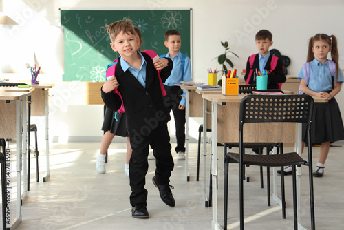 Fotografía Cute little schoolboy running in classroom