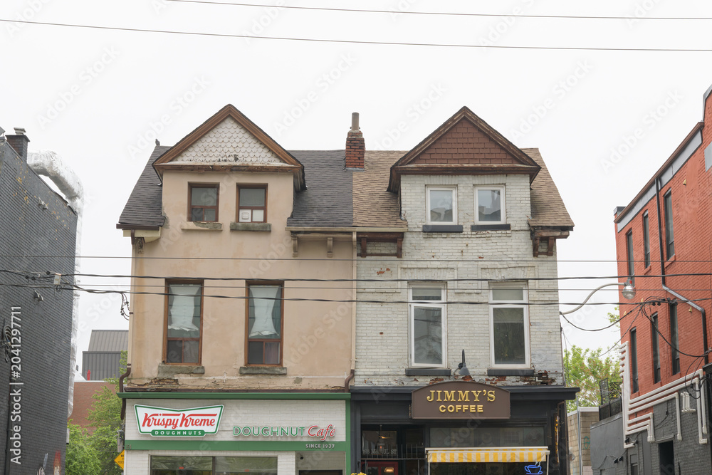 Naklejka premium historic houses and exterior building facade with signs of Krispy Kreme Café and Jimmy's Coffee (164-166 McCaul St), Toronto