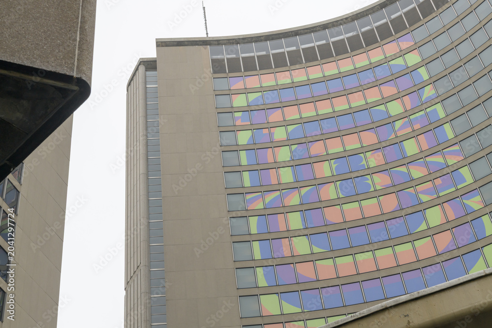 Naklejka premium Toronto City Hall (100 Queen St W), designed by architect Viljo Revell in the Modernist style, features twin curved concrete towers cradling a central, saucer-shaped council chamber