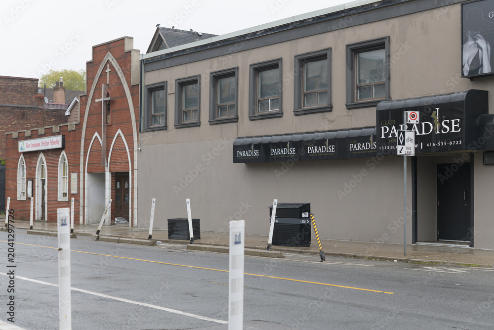 Naklejka premium wide view of Bloor Lansdowne Christian Fellowship and neighbor Club Paradise, an adult entertainment club, located at 1307-1313 Bloor St W, Toronto