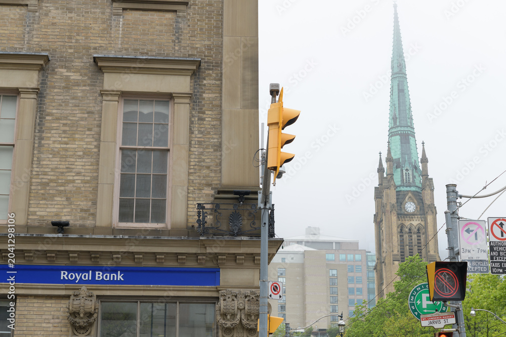 Naklejka premium RBC Royal Bank sign on the east facing wall of St Lawrence Hall (161 King St E at Jarvis St) with view of steeple at St James Cathedral Church, Toronto