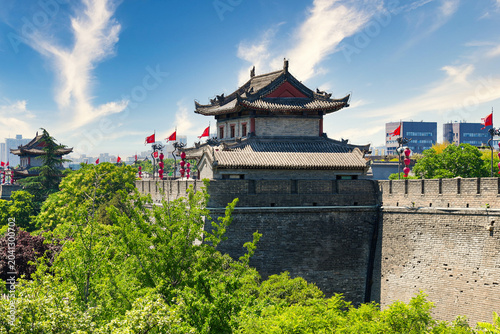 Фотография Perspective view of the ancient massive stone wall and watchtower adorned with r