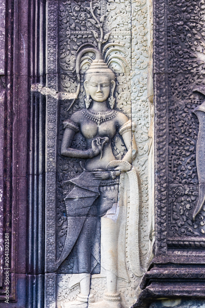 Naklejka premium Apsara dancer carved in stone at Angkor Wat temple complex, Siem Reap, Cambodia. These celestial dancers are a common motif in Khmer art.