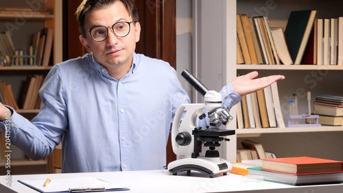 Fotografija Scientist wearing glasses shrugging with open palms, expressing uncertainty and