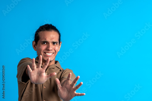 Tableau sur toile Young man pushing stop gesture expressing aversion