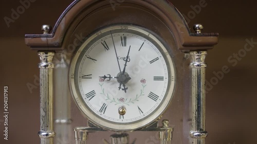 Close up of vintage antique mantel clock with roman numerals ticking time