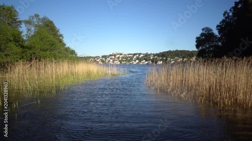 Stockholm, Sweden A picturesque view of a narrow grassy passage on Lake Malaren from a moving boat. 