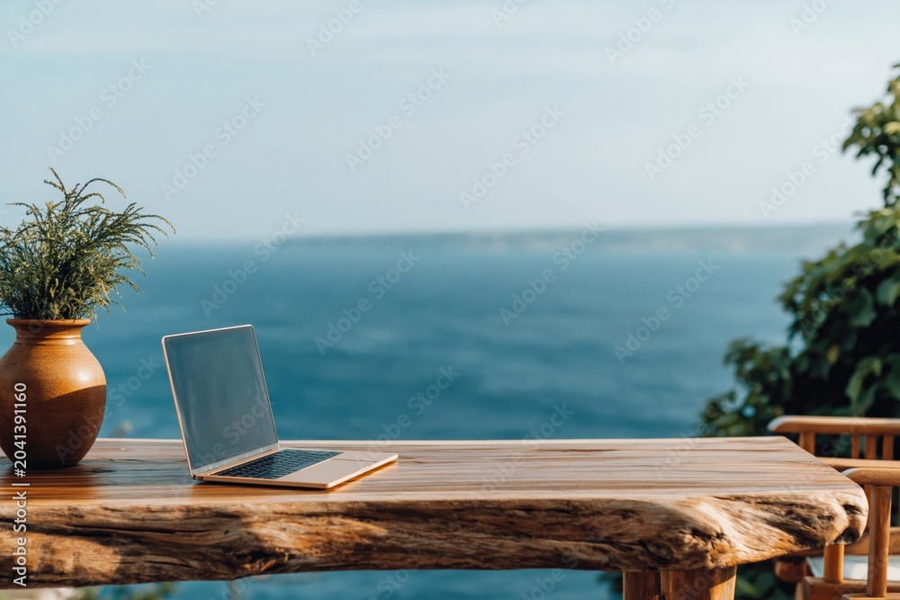 Fototapeta premium Laptop on wooden table with ocean view for remote work nomad tropical sea