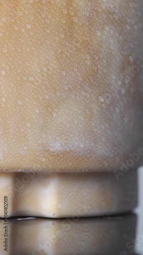 4K close-up of rich espresso swirling and mixing into fresh white milk in a glass, Abstract iced coffee latte texture beverage background, food styling concept.