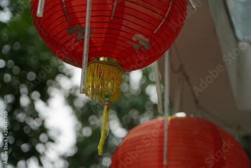 A close-up shot of traditional red Chinese lanterns hanging outdoors, captured from a low angle looking upward