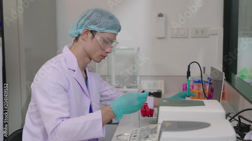Young researchers are analyzing samples and taking notes in the science lab. A team of lab technicians is working with microscopes and recording research data.