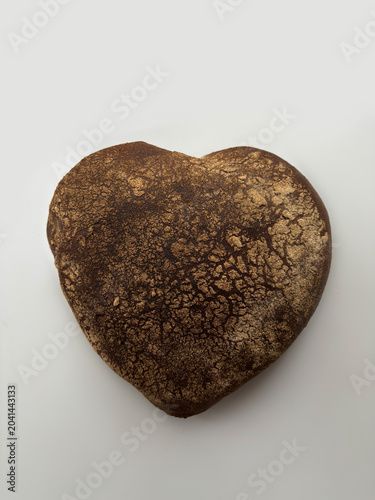 Rye bread in the shape of a heart on a white background.