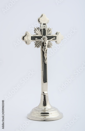 Photography Polished metal crucifix cross on stand shown from three quarter angle
