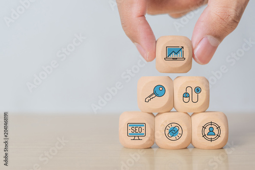 Hand Placing Wooden Blocks with SEO and Digital Marketing Symbols