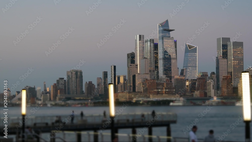 Obraz premium New York City Manhattan Midtown skyline, Chelsea and Hudson Yards towers from New Jersey, Hoboken pier, United States. River waterfront urban cityscape with skyscraper buildings, Evening dusk twilight