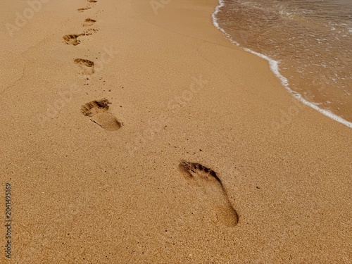 Footprints on wet sand at the beach