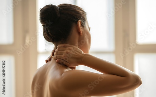 Woman feeling pain in neck holding her head with hand, feeling unwell.
