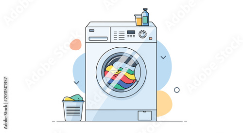 White automatic washing machine with colorful clothes inside and a laundry basket and detergent bottles placed on and around it.
