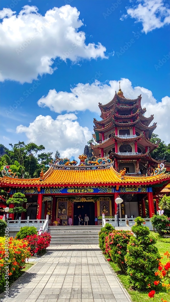 Obraz premium Traditional asian temple against blue sky with white clouds on sunny day