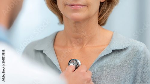 A doctor’s hand is gently placing the diaphragm of stethoscope on the patient’s chest